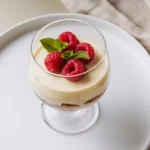 White chocolate mousse in glass with raspberries