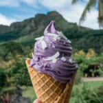 Scoop of ube ice cream in cone with tropical background