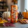 Alani Pumpkin Cream energy drink with fall leaves on wooden table