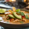 Creamy chicken tortilla soup topped with avocado and tortilla strips